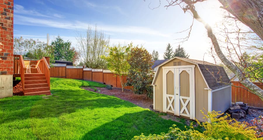 Fenced backyard with storage shed in College Station